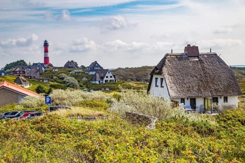 Lighthouse and thatched-roof villas of the Kersig estate in the dunes, Hörnum, Sylt