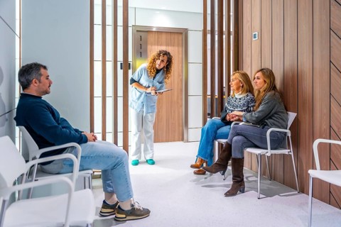 Nurse checking the list of patients in the waiting room of an hospital