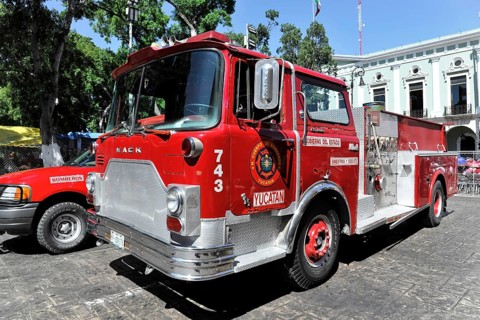 Merida, Yucatan, Mexico, Central America, Red fire engine on a city street, surrounded by historic