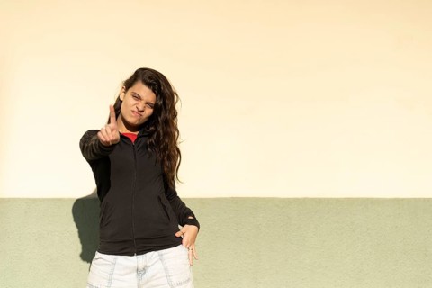 Latin teenager in a the street saying no with her hand. Stop concept. Rejection concept.