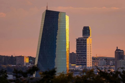 The light of the setting sun falls sideways onto the glass façade of the European Central Bank