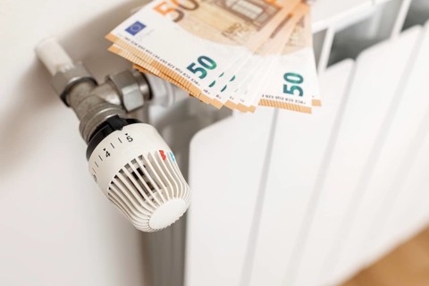 Close up of Euro banknotes on a heating radiator. Energy cost crisis concept