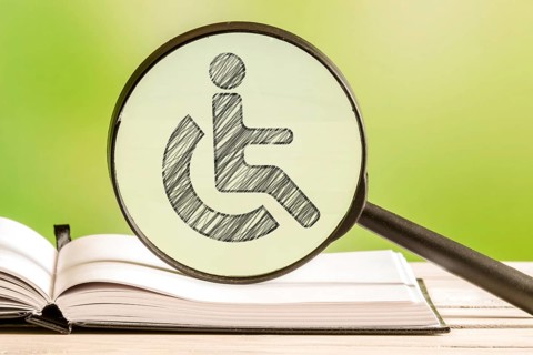 Handicapped info with a pencil drawing of a disabled icon in a magnifying glass