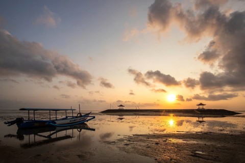 Morning landscape taken on the sandy beach. View over the sea to the horizon with small temples in