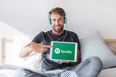 Young man holding tablet with spotify app