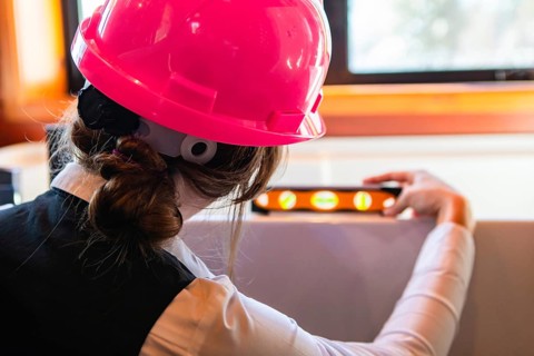Construction quality control. close up rear view of a woman architect at work, she using a spirit