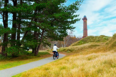 Woman cycling towards the lighthouse on Norderney