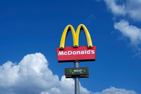 Mc Donalds logo in the blue sky with white clouds