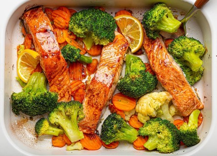 Top view close up of healthy baked fish salmon steaks, broccoli, cauliflower, carrot in casserole