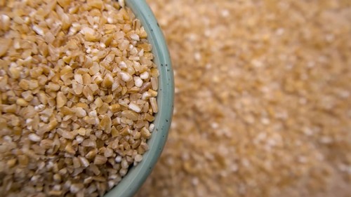 Cracked Broken Wheat Porridge (Dalia) in a Blue Bowl, Top View, Flat Lay, Closeup
