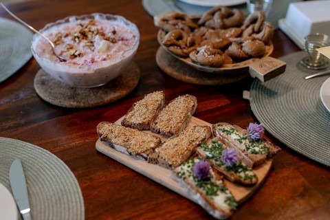 Breakfast table with muesli, bread rolls & pretzels