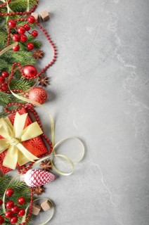 Flat lay view at Christmas decorations of gift box fir branch ribbon beads and glass balls on stone
