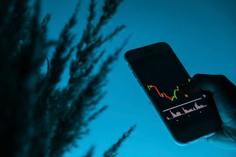 Woman holding mobile phone, block chain with graph of stock market background, cryptocurrencies or