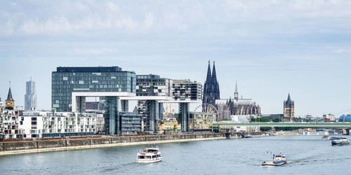 Excursion and cargo ships on the Rhine in front of the impressive panorama of Cologne with the