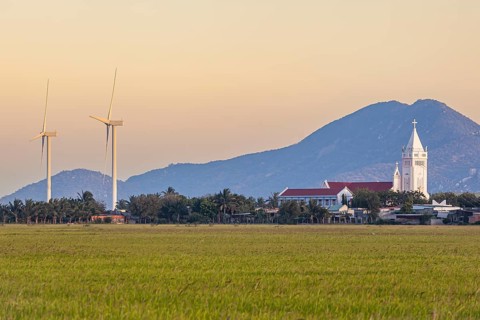 Landscape with rice fields and wind turbines and a Catholic church at Phan Rang, Ninh Thuan