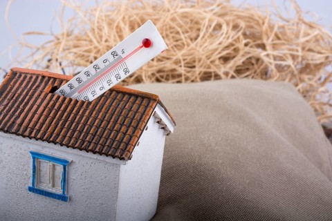 Thermometer measuring high temperature placed on a little model house