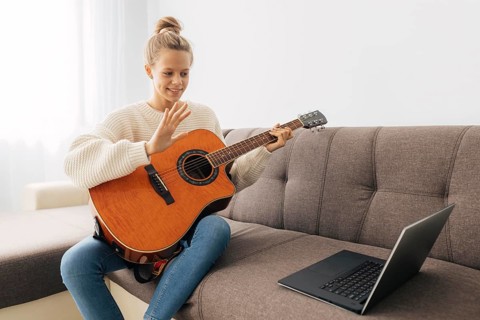 Young girl playing guitar home