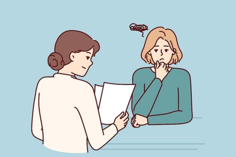 Woman is interviewing in corporation and is nervous waiting for recruiter to read resume and make