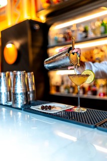 Vertical photo of an unrecognizable bartender preparing a luxury cocktail on a bar