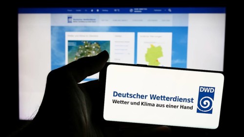 Stuttgart, Germany, 06-06-2024: Person holding mobile phone with logo of German meteorological