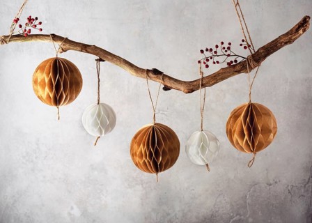 Handmade honeycomb balls hanging on a tree branch as a beautiful Christmas decoration. Scandinavian