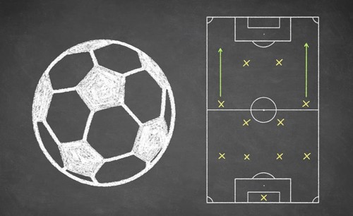 Soccer ball and tactical scheme drawn on chalkboard. White chalk and balckboard