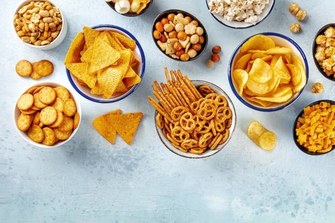 Salty snacks, party mix, overhead flat lay shot with copy space. An assortment of appetizers, shot