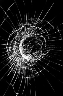 Crack on a broken glass mirror on a white background line of fragments of a sphere