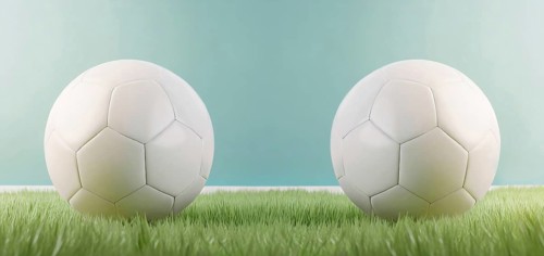 Two white football balls placed against each other on the green grass. Soccer scoreline symbols