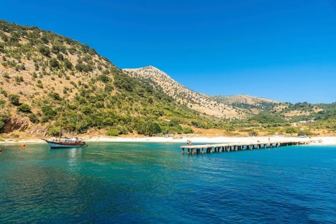 Boat pier at Kakome Beach seen from the boat on the Albanian riviera near Sarande and its turquoise