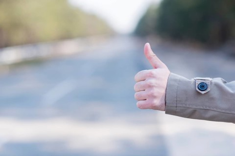 Close up man s hand hitchhiking countryside road