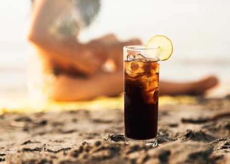 Glass coke with ice beach