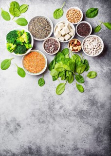 Top view of different vegan protein sources with space for text: beans, lentils, quinoa, tofu,