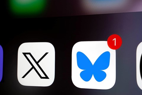 A close up of an iPhone screen displaying the X (twitter) app icon and the Bluesky app icon