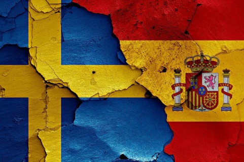 Flags of Sweden and Spain painted on cracked wall