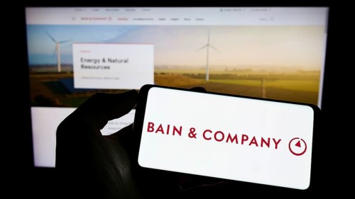 Stuttgart, Germany, 06-11-2022: Person holding cellphone with logo of US consulting company Bain