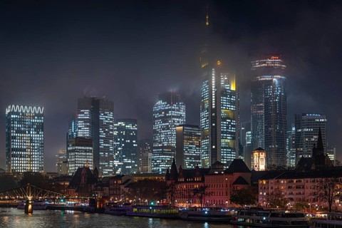 Low clouds envelop the shining towers of Frankfurt's banking skyline in the evening. Frankfurt am