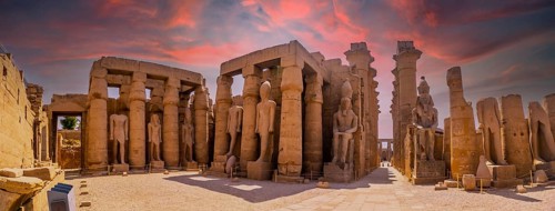 Sculptures of ancient Egyptian pharaohs and drawings on the columns of the Luxor Temple in the