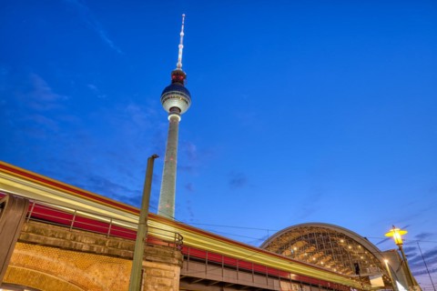 Local train entering Alexanderplatz station in Berlin at dusk