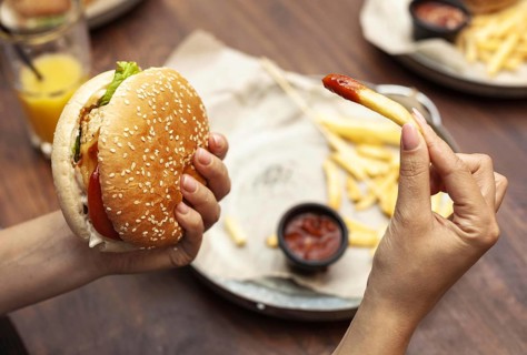 High angle person eating burger french fries