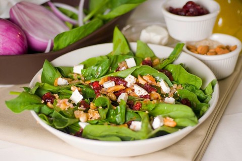 Plate of fresh colorfull spinach salad close up