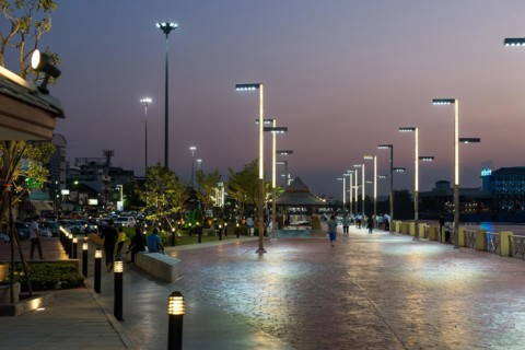 People, locals and tourists stroll and relax on the promenade of the Tapi river in Surat Thani