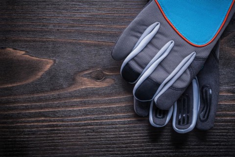 Pair of protective gardening gloves on wooden board agriculture concept