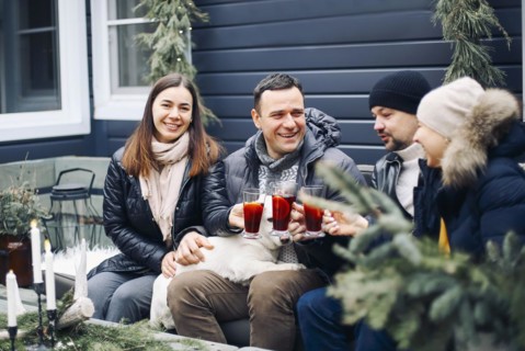 Bonfire party. Joyful young family couple gathering with friends around campfire in winter, happy