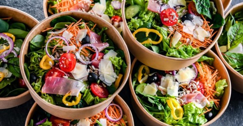 Round paper boxes with pre-packaged vegetable salads ready for sale