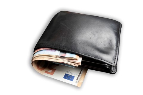 wallet filled with lots of cash isolated on white background