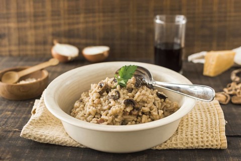 Close up mushroom risotto white bowl with spoon napkin table. Resolution and high quality beautiful