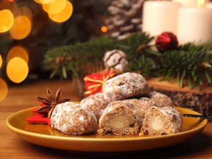Delicious Christmas stollen on a ceramic plate in front of an Advent wreath and Christmas