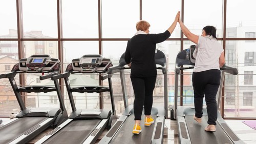 Women treadmill high five