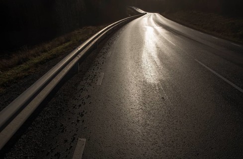 Country road, wet and shiny against the light, black and white, road 175 near Nysäter, Värmland,